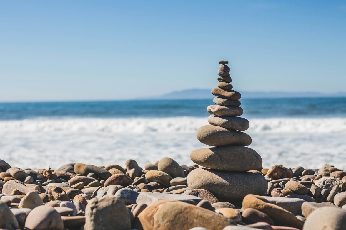 A stack of rocks on a beach with waves in the background