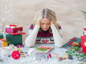 A photo of a middle aged woman holding her head and looking stressed