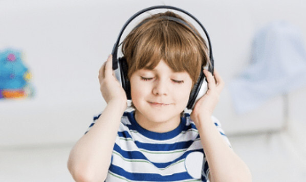 A young boy with headphones on listening to music