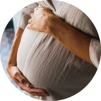 A pregnant woman holding her belly.